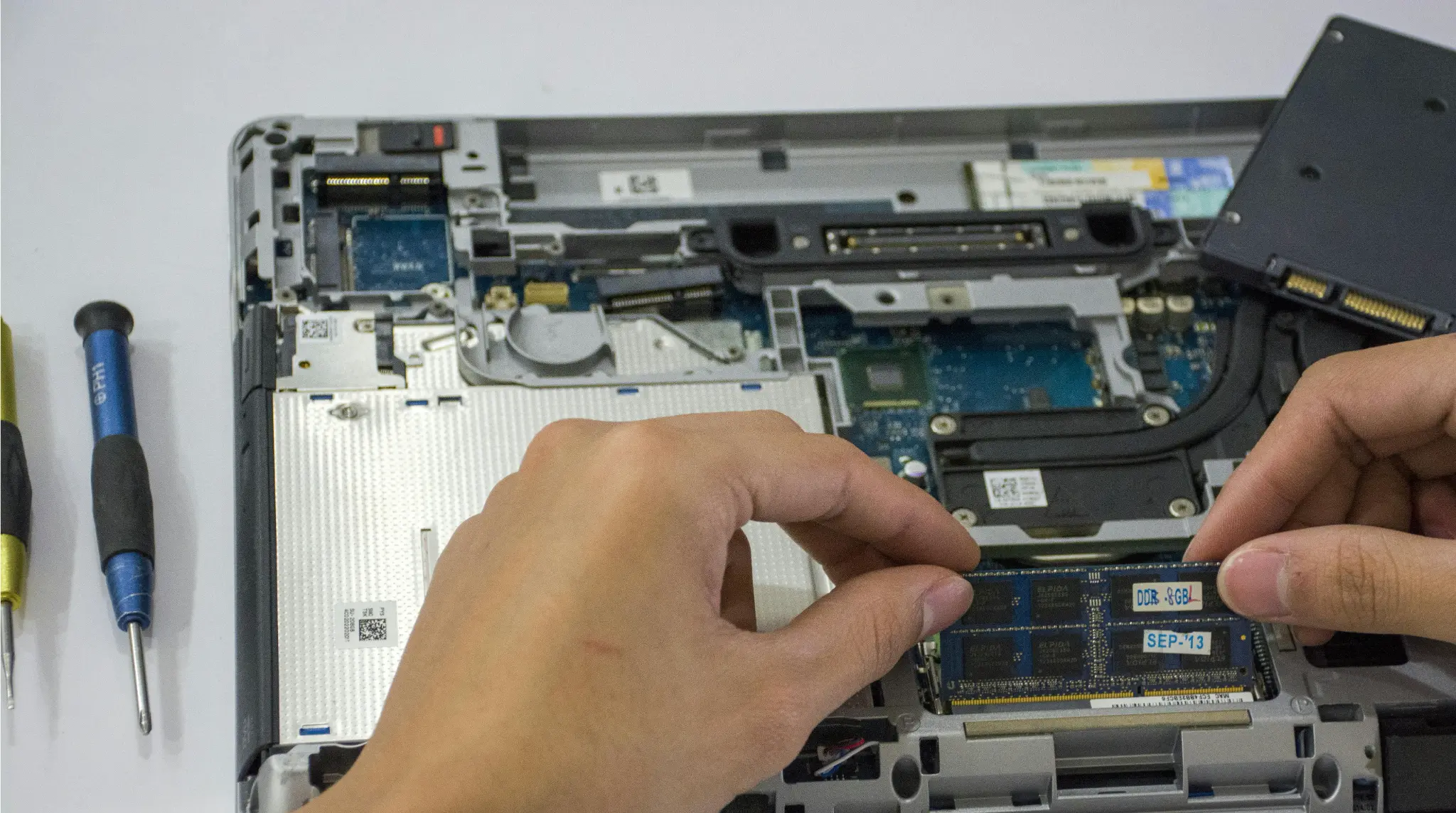 Computer repair technician evaluating laptop for repair or replacement